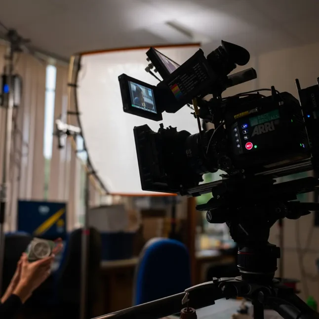 A behind the scenes still of a camera from an education video shoot